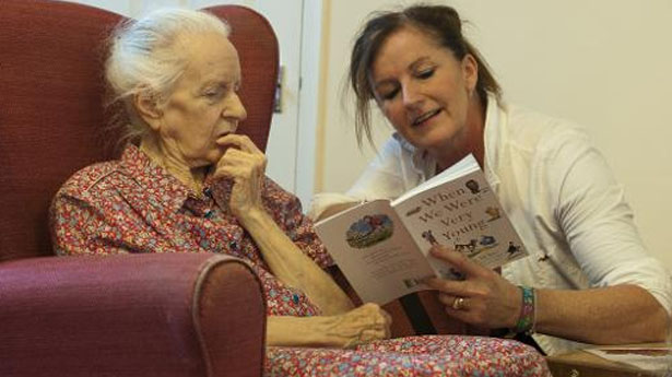 A-volunteer-from-the-Kissing-it-Better-charity-read-poems-on-October-29-2013-to-a-resident-of-a-retirement-home-in-Stratford-AFP[1]