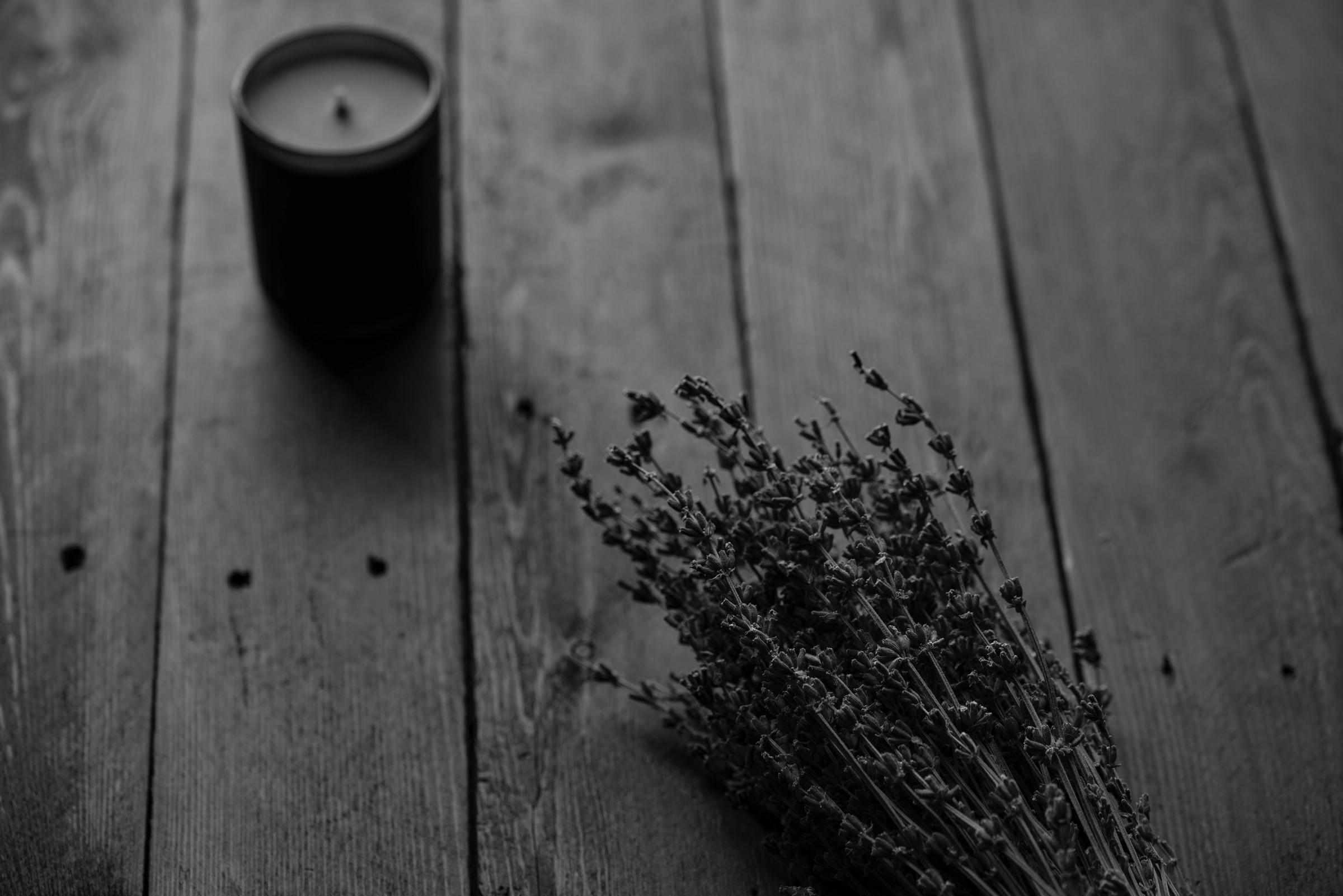 A candle and twigs on a wood table