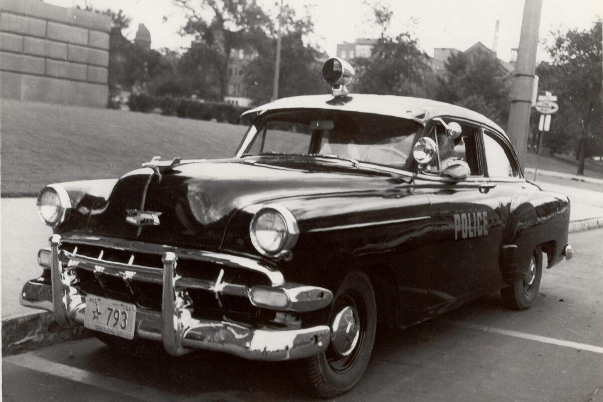 Black and white photo of a 1950s police car